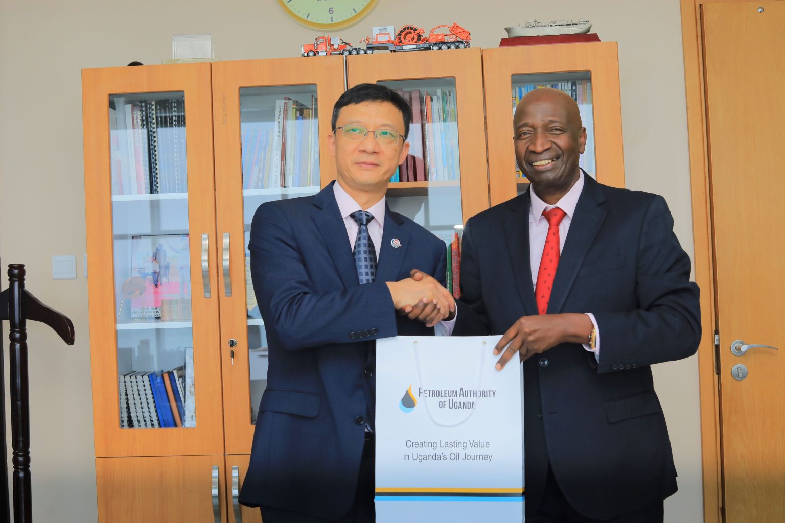 The new President of CNOOC Uganda Limited, Mr. Liu Xaingdong (L) poses with Mr. Ernest Rubondo, the Executive Director of the Petroleum Authority of Uganda (R)
